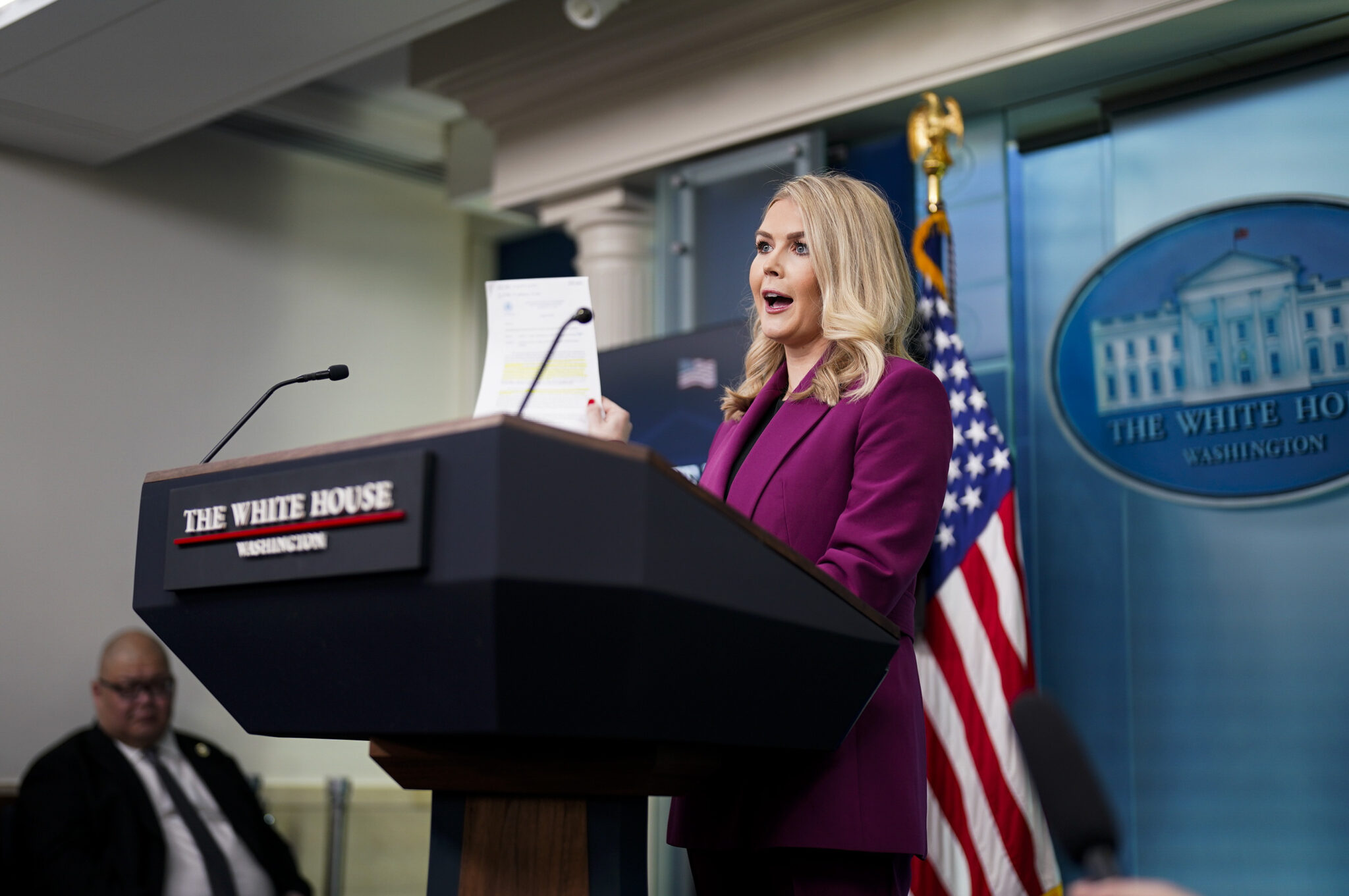 White House Press Secretary Karoline Leavitt holds a printed page aloft during a press briefing.